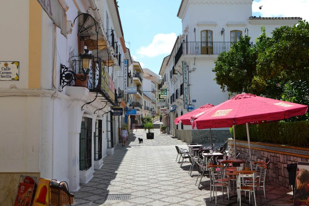 Una calle con edificios encalados y terrazas en Estepona.